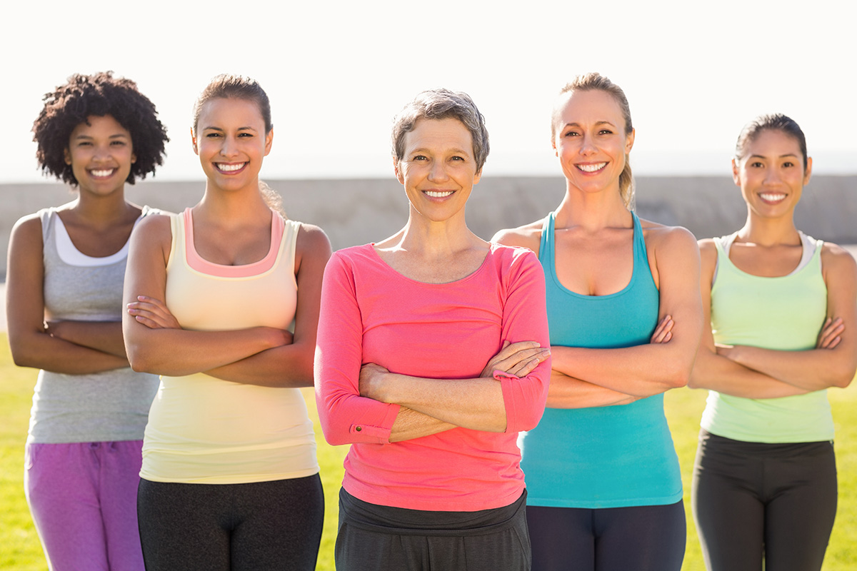 Gruppe Frauen in sportlichen bunten Outfits lächeln