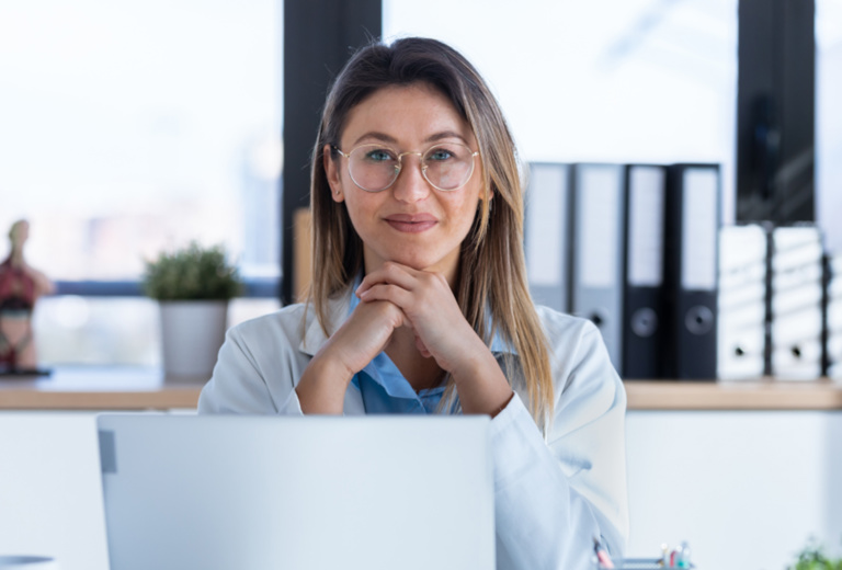 Frau in Kittel arbeitet an einem Rechner in star.net® Labor